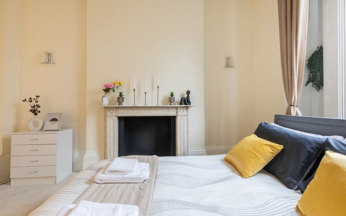 Bedroom with a period fireplace in the King's Cross apartment we operate