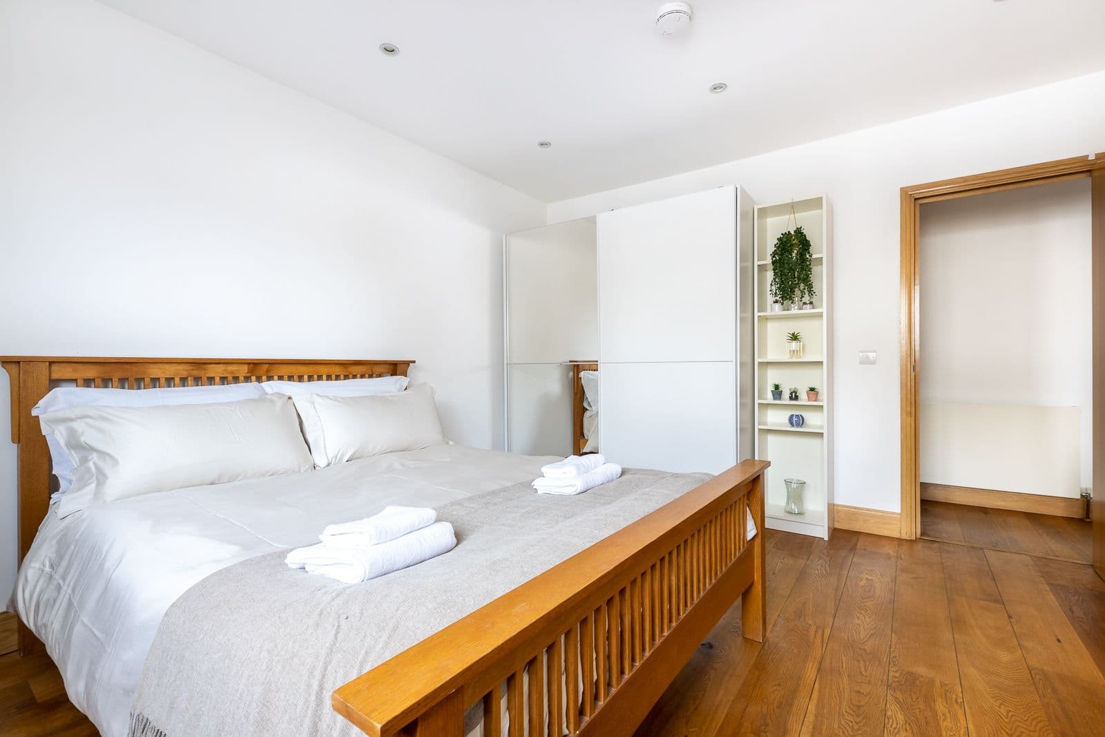 A bed made up with folded towels, ready for the next guest, in one of our apartments