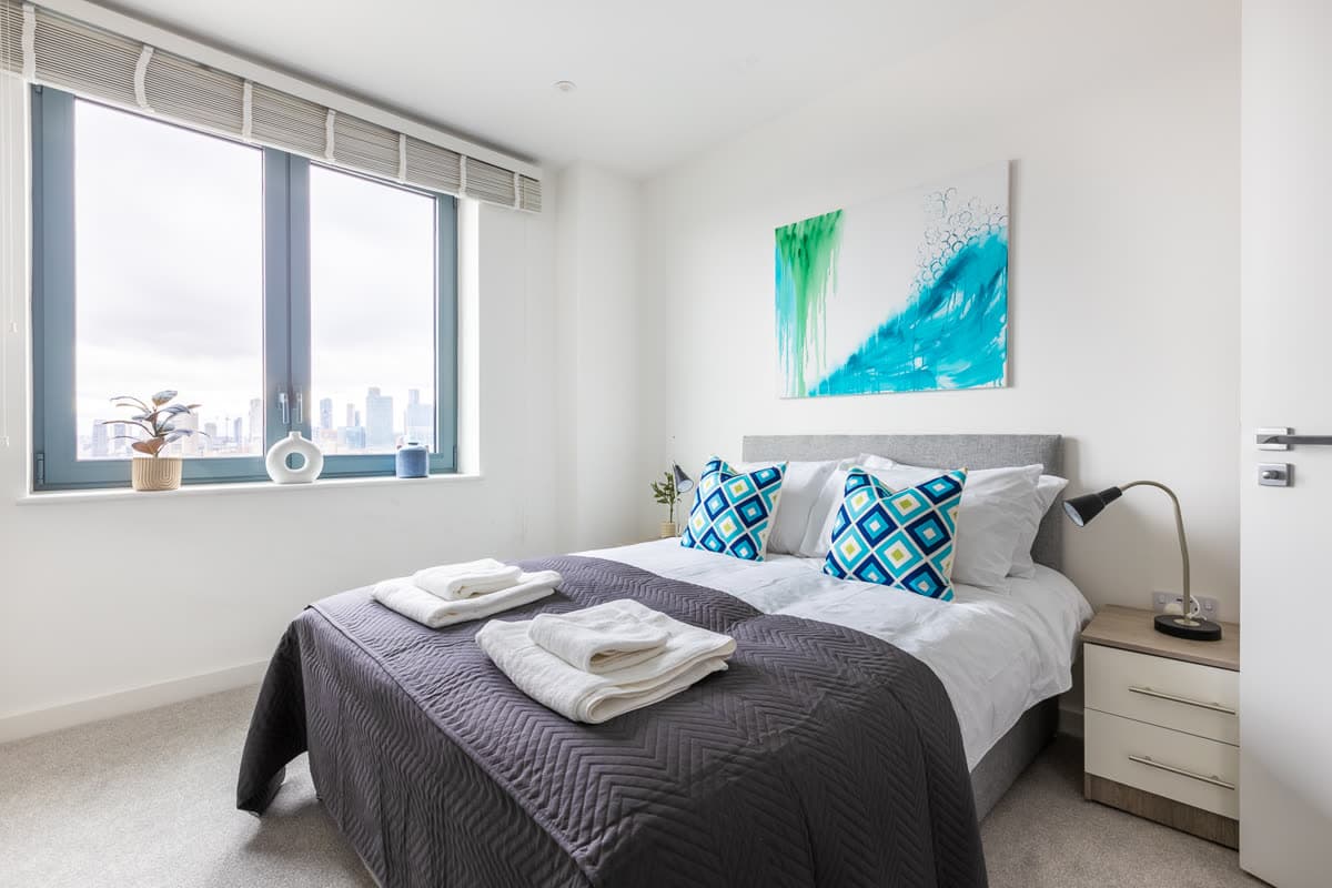 Bedroom made up after a turnaround, with fresh towels laid out