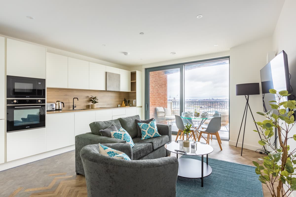 Kitchen and living space opening onto a balcony in an apartment we operate